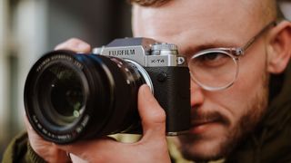 Man holding Fujifilm X-T4 to face