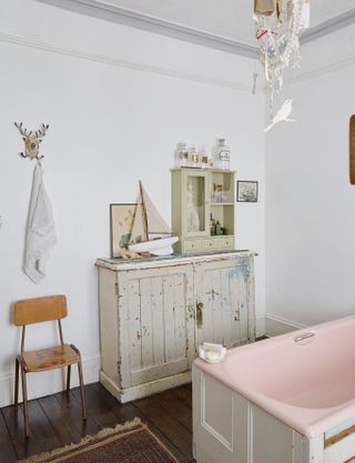 pink bath in bathroom with vintage style cabinet