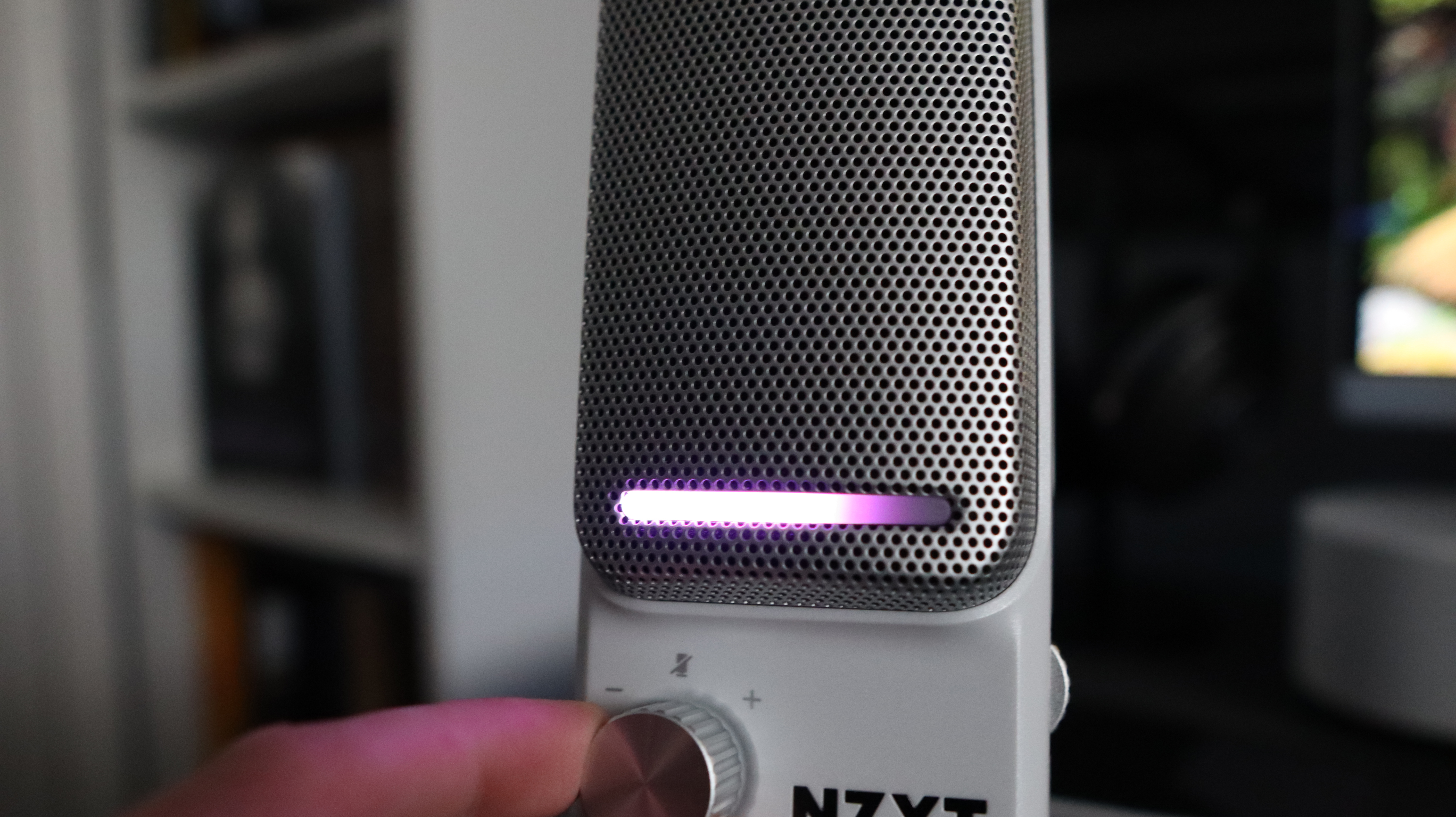 An NZXT Capsule Elite microphone set up on a desk with lighting enabled.