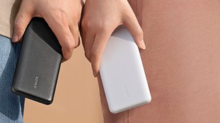 Two people holding two Anker powerbanks