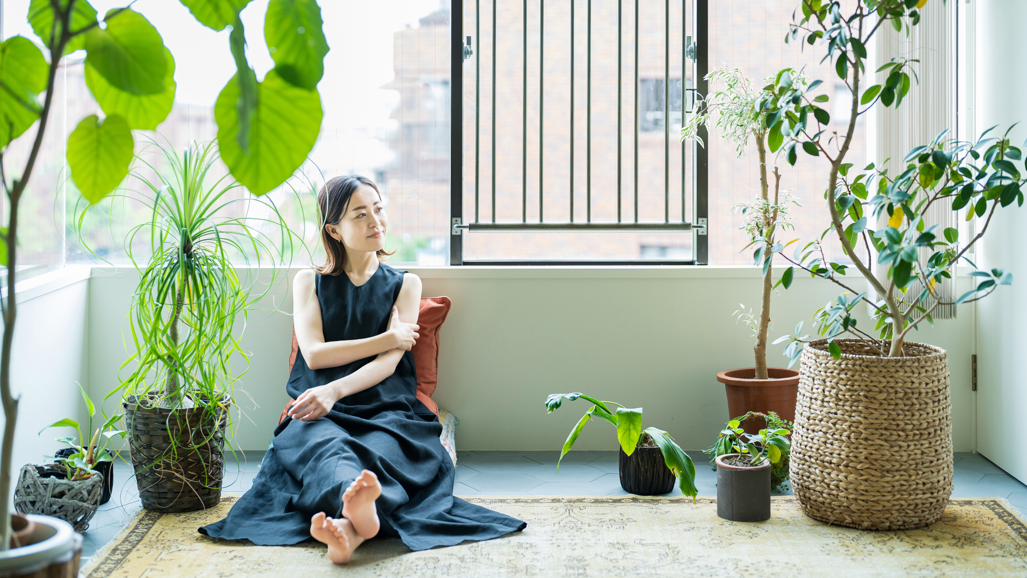 woman forest bathing indoors with large houseplants 