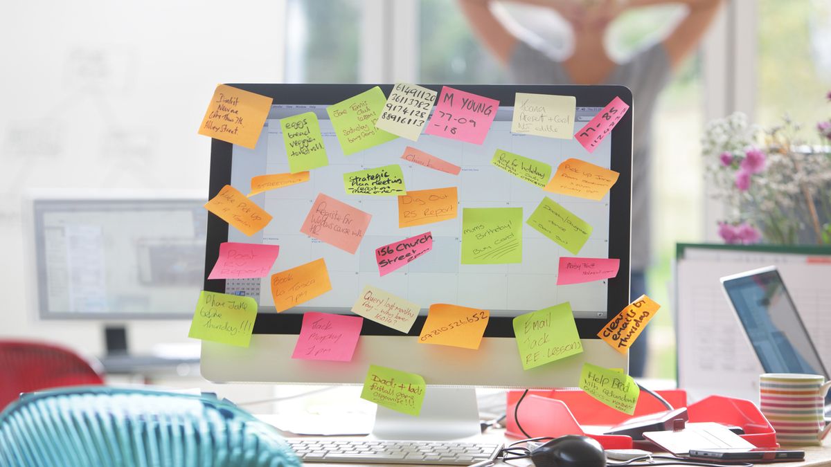 woman leaving post-it notes on her computer