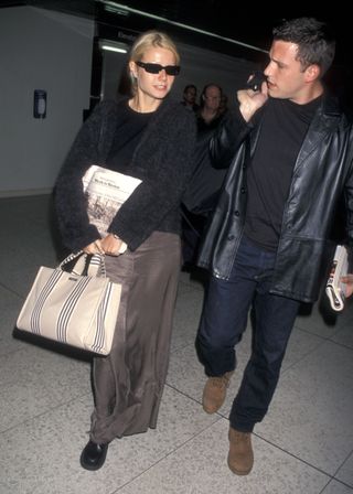 Gwyneth Paltrow carrying a Kate Spade Sam Bag with Ben Afflack at the airport in 1998