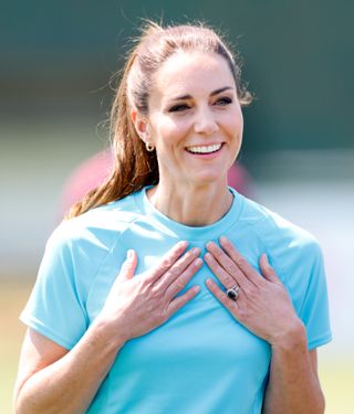 Kate Middleton puts her hands on her chest while playing rugby