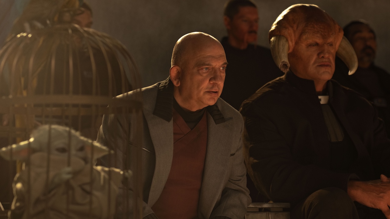 Lord Janu sitting next to Grogu trapped in a birdcage in The Mandalorian and Grogo