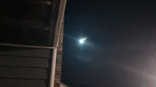A bright meteor is photographed lighting up the night sky. 
