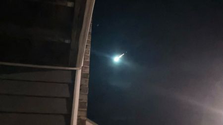 A bright meteor is photographed lighting up the night sky. 
