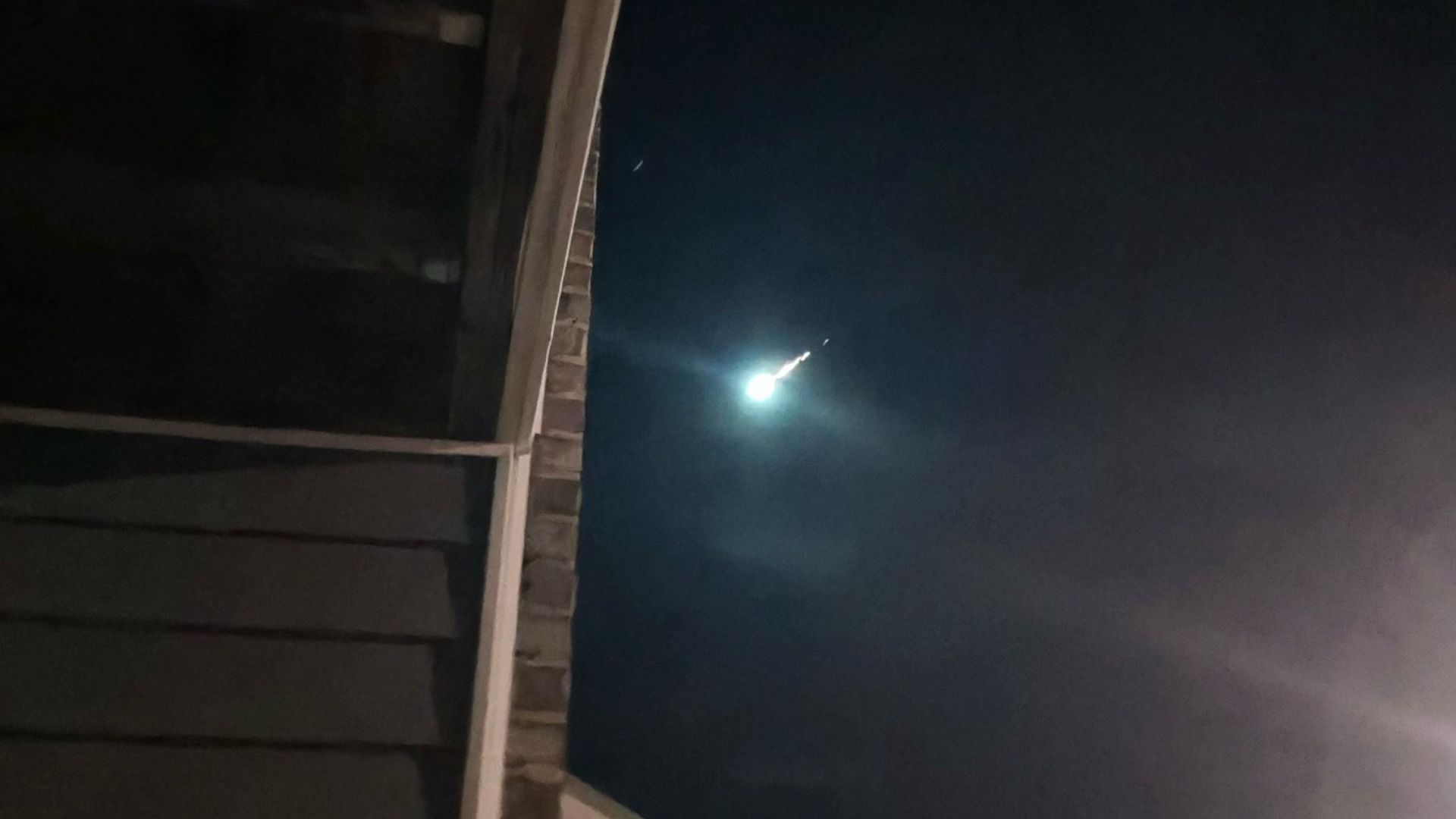 A bright meteor is photographed lighting up the night sky. 
