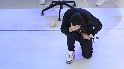 Eminem kneels during the Super Bowl LVI halftime show.