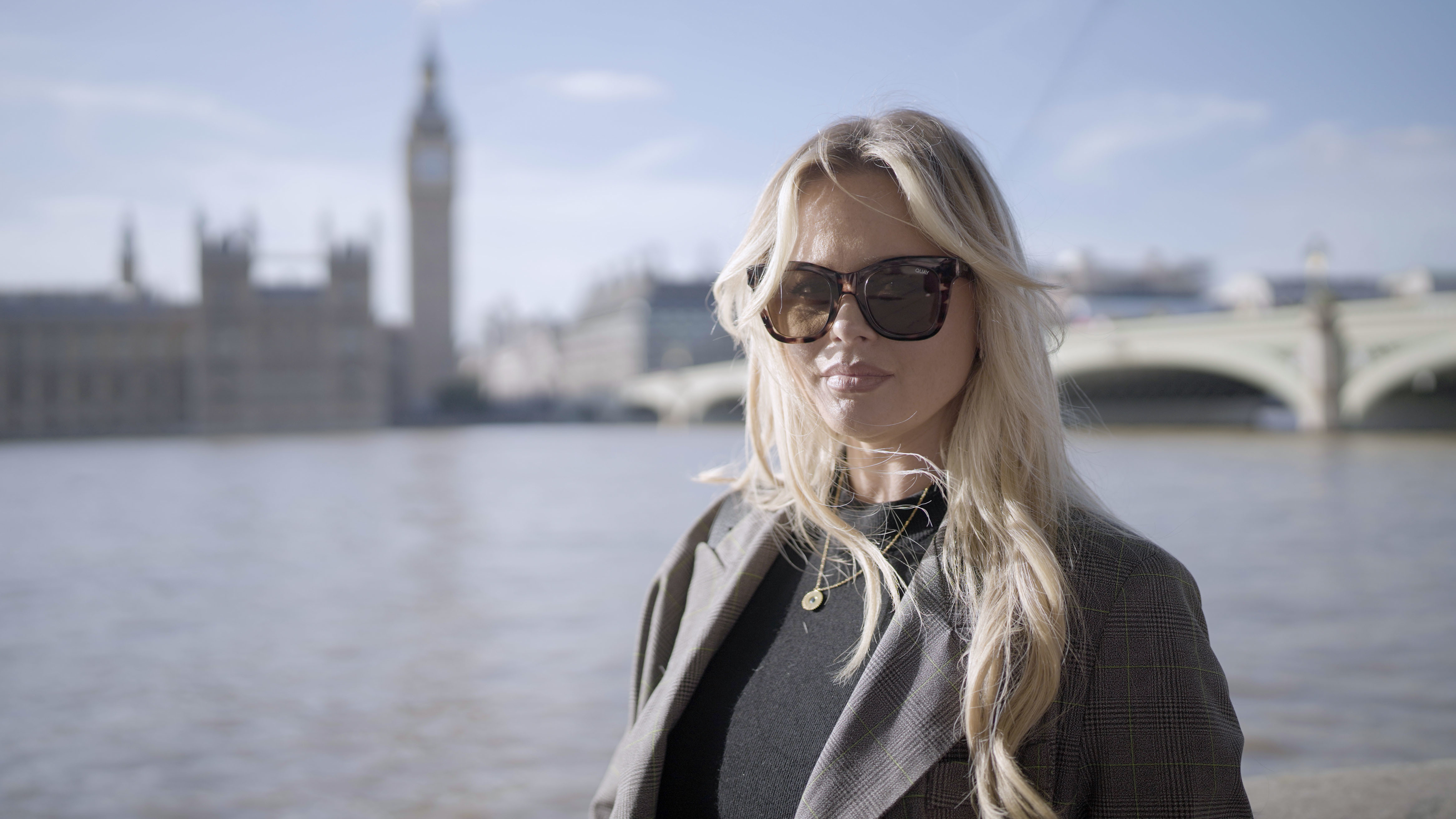 Emily Atack wearing sunglasses in front of the London skyline