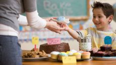 School fundraising ideas illustrated by boy on cake sale