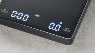 a black square coffee scale by Maestri House with a timer and a rechargeable battery