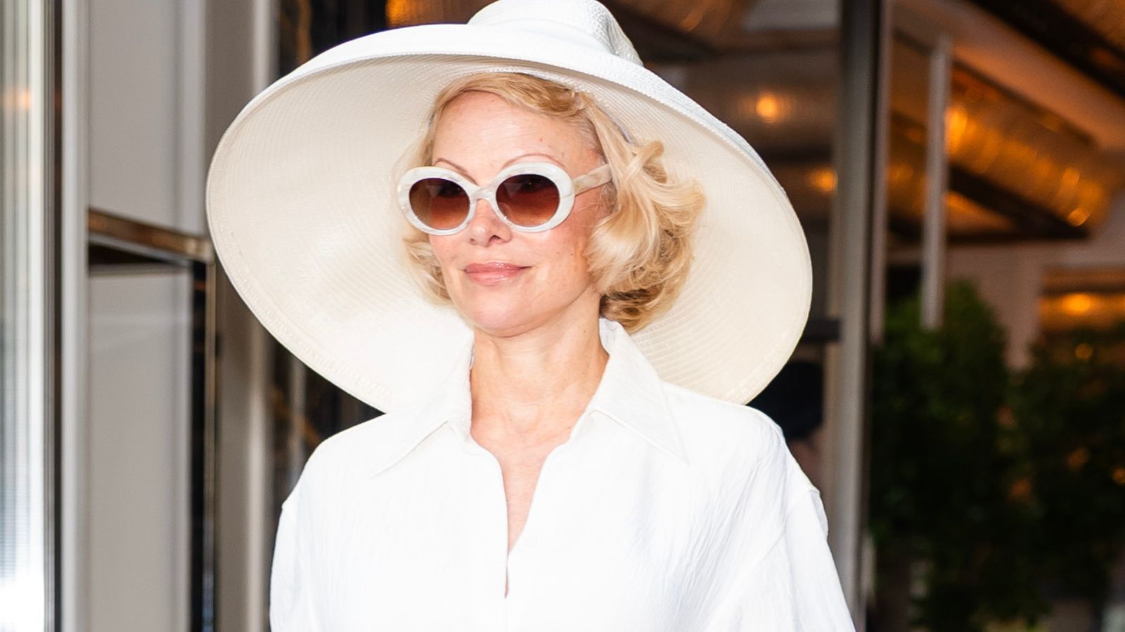 Pamela Anderson in a white hat and sunglasses