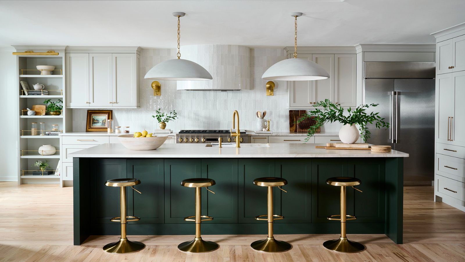 A large kitchen with white cabinets, a green island, and a white zellige backsplash and matching tiled range hood