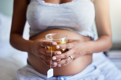 Woman drinking raspberry leaf tea during pregnancy