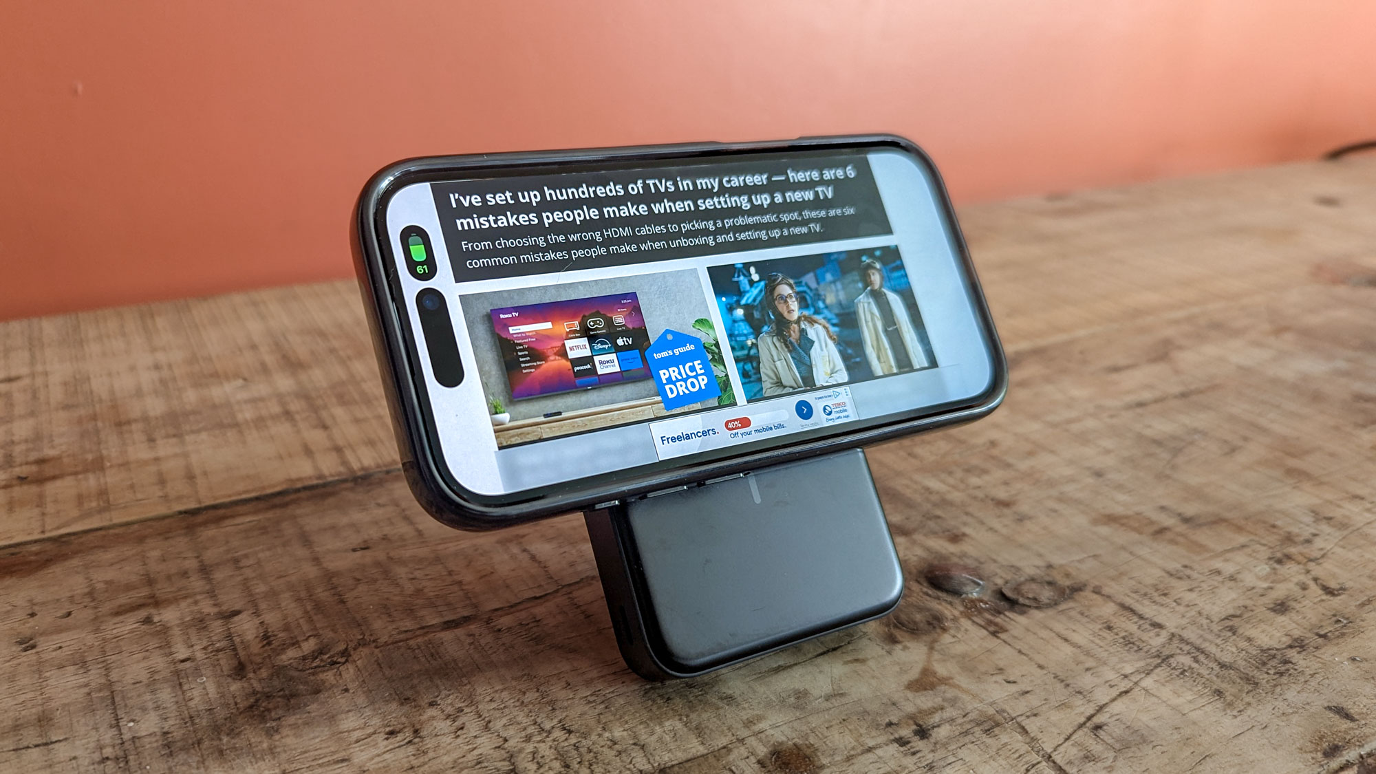 Anker MagGo Power Bank on table with iPhone 16 showing Tom's Guide website attached