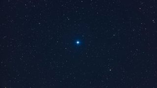 a bright blue star in the night sky