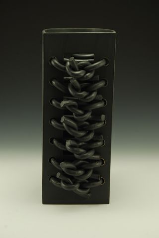 Black ceramic vessel featuring a knotted motif at the front, by American artist Paul S. Briggs