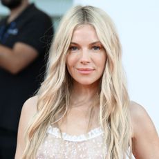 Sienna Miller wears a floor-length leopard print dress at a party in London.