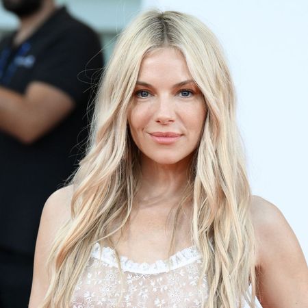 Sienna Miller wears a floor-length leopard print dress at a party in London.