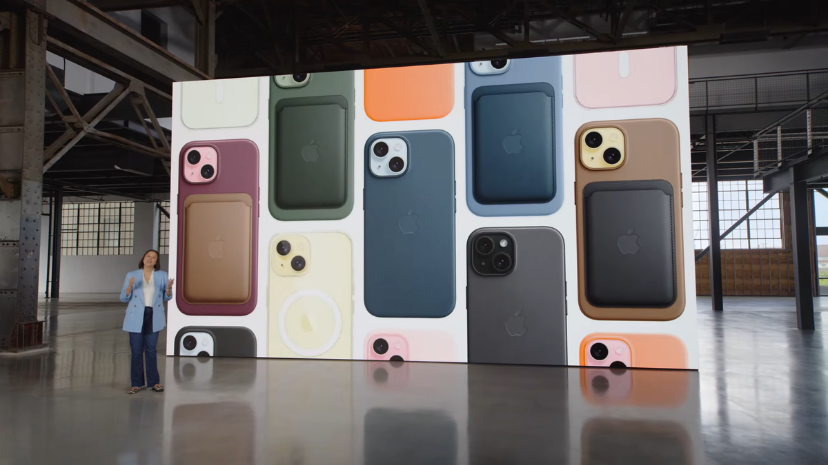 A screen in a warehouse covered in iPhone 15s with cases, wallets and other accessories attached to them. 