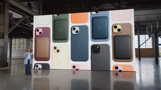 A screen in a warehouse covered in iPhone 15s with cases, wallets and other accessories attached to them. 