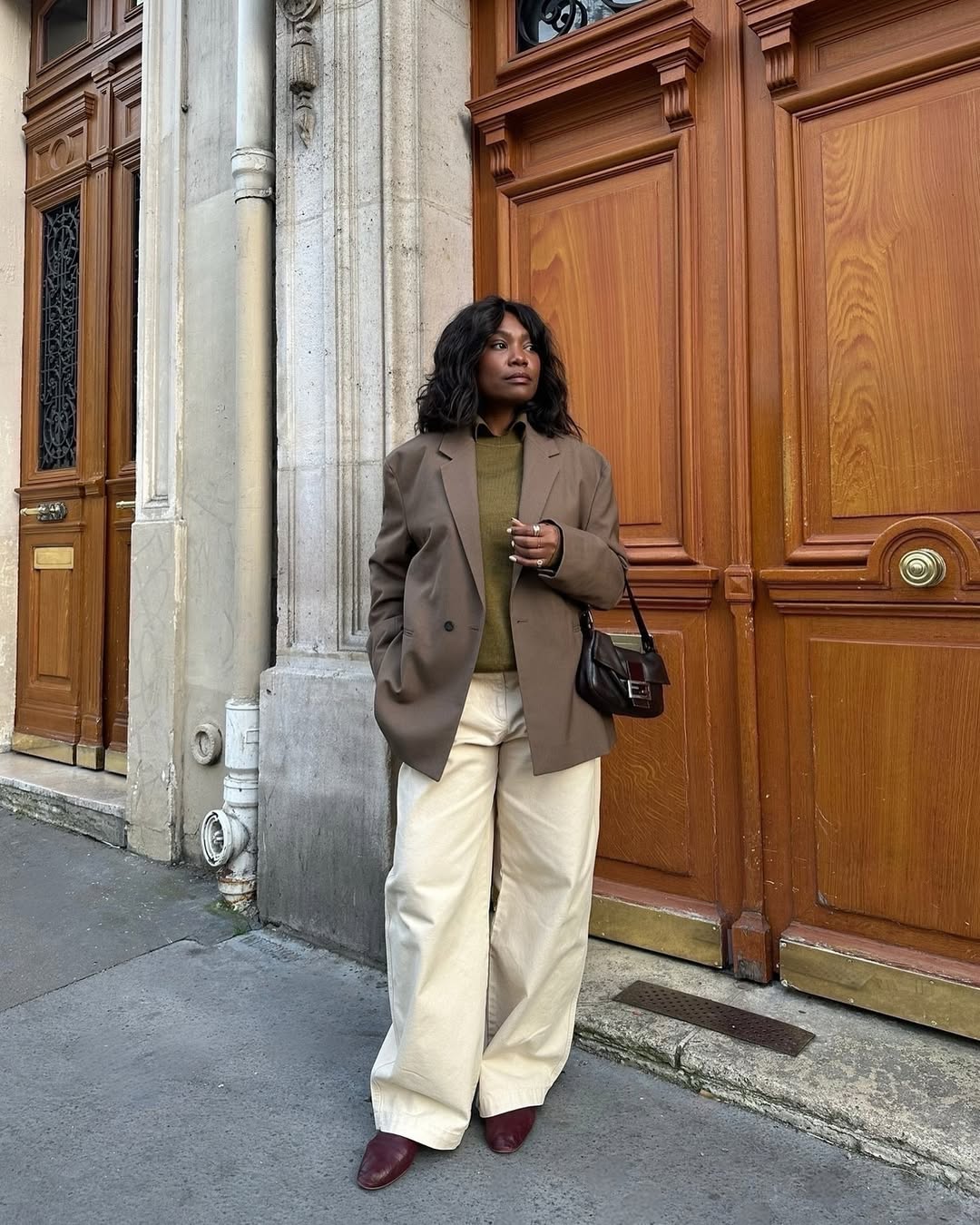 Franny with a small handbag and brown blazer