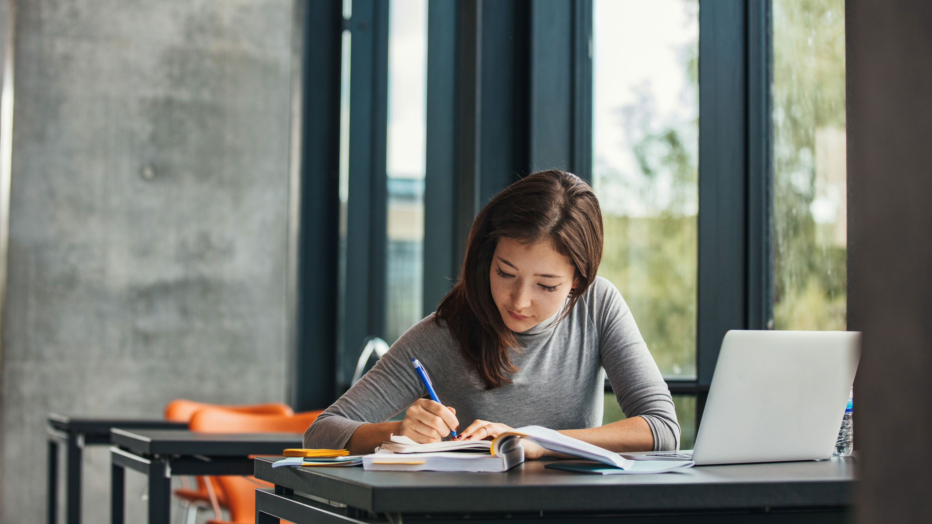 Young female student studying in library.