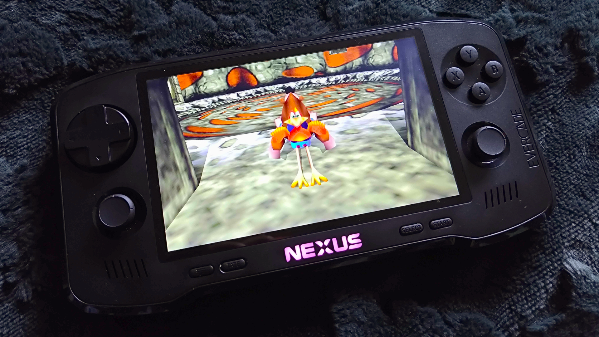 Evercade Nexus handheld with Banjo-Tooie gameplay on screen with Kazooie in trot mode.