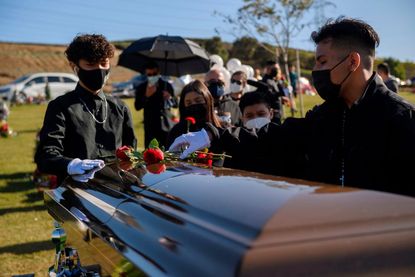 People gather for the funeral of a coronavirus victim.