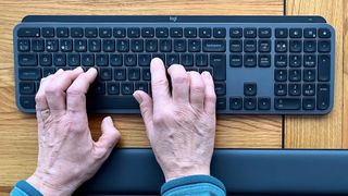 Hands typing on a Logitech MX Keys S keyboard