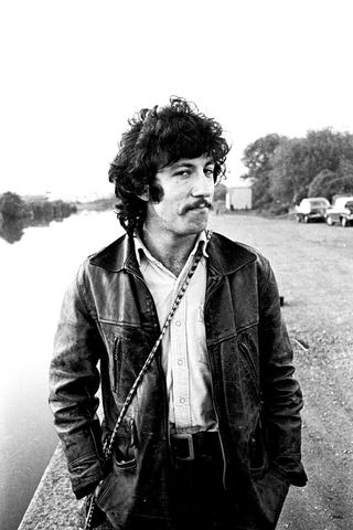 Peter Green standing next to a canal