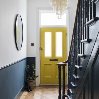 Yellow front door in a hallway
