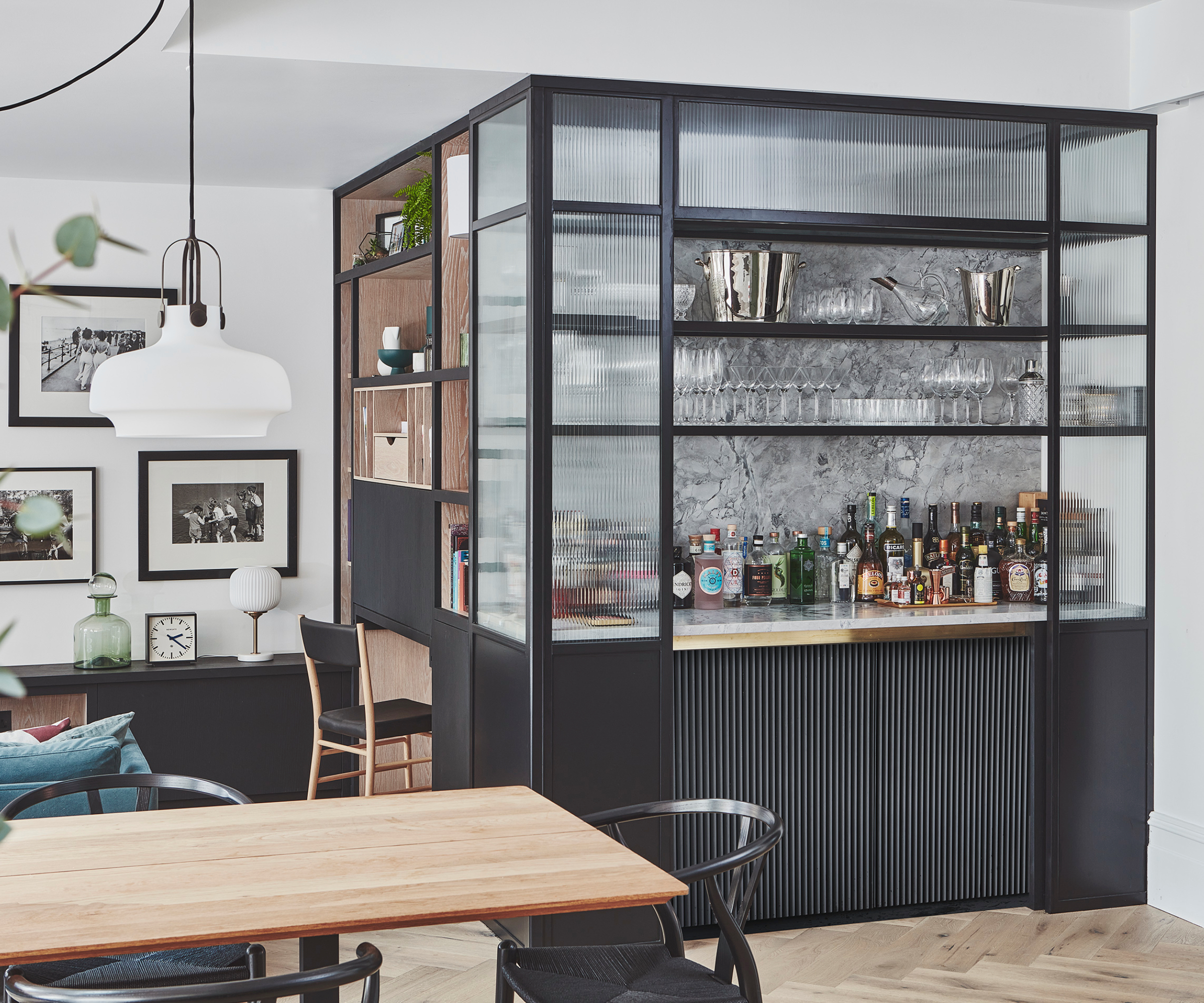 Black Crittall style bar area with marble splashback