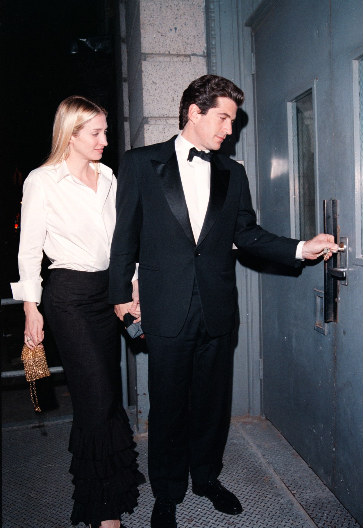 Carolyn Bessette Kennedy arrives home with her husband in a white shirt and column skirt