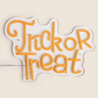 An orange neon sign that says 'Trick or Treat'