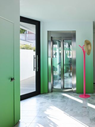 seafoam green entryway with pink lamp