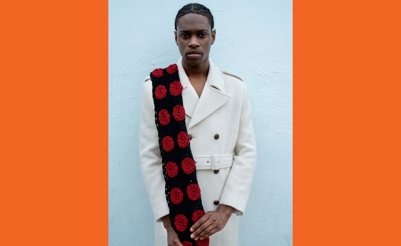 Model wears white trench coat and floral scarf by Ernest W Baker