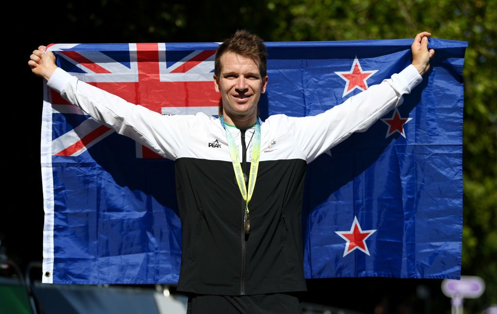 WARWICK ENGLAND AUGUST 07 Gold Medalist Aaron Gate of Team New Zealand celebrates with their flag during the Mens Road Race medal ceremony on day ten of the Birmingham 2022 Commonwealth Games at on August 07 2022 on the Warwick England Photo by Justin SetterfieldGetty Images