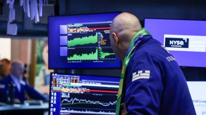 A trader views stock information on the floor of the New York Stock Exchange. 