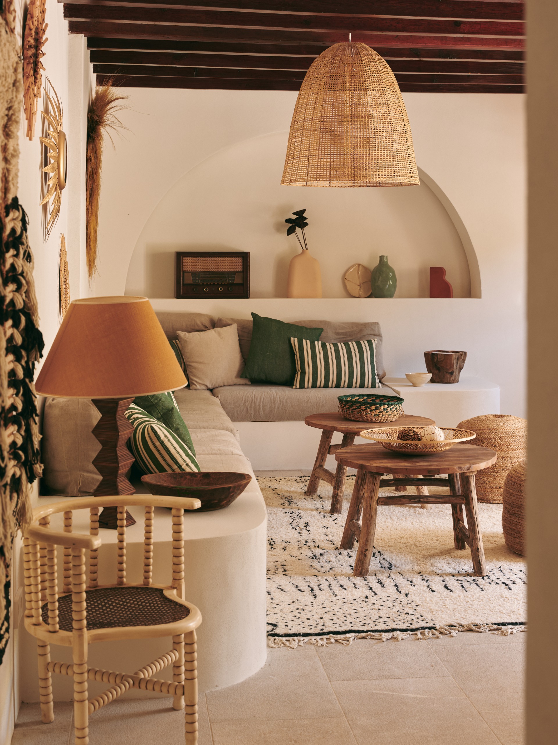 built-in seating area with arched shelves, wooden beams on the ceiling, and natural material accessories