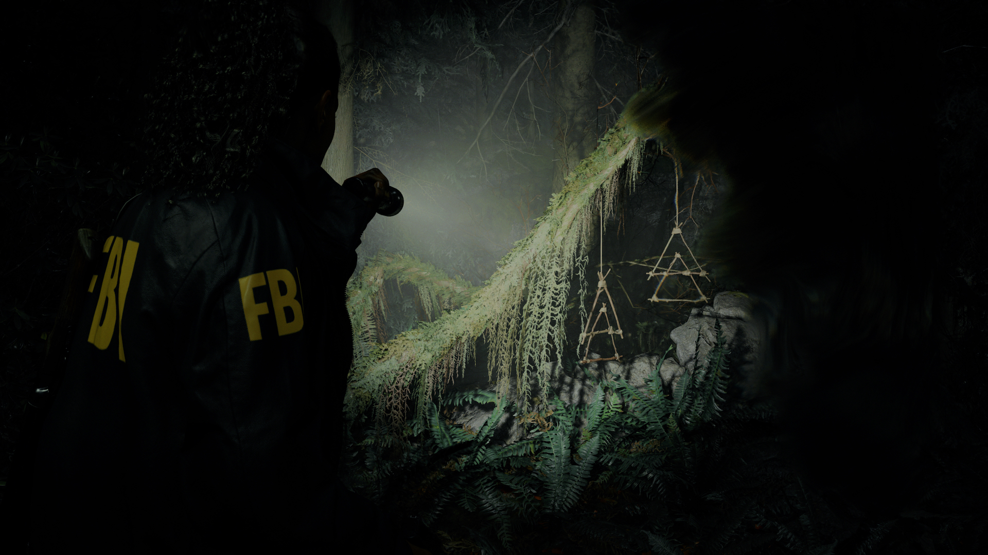 An FBI agent shines a torch over ritualistic items left in a woodland setting