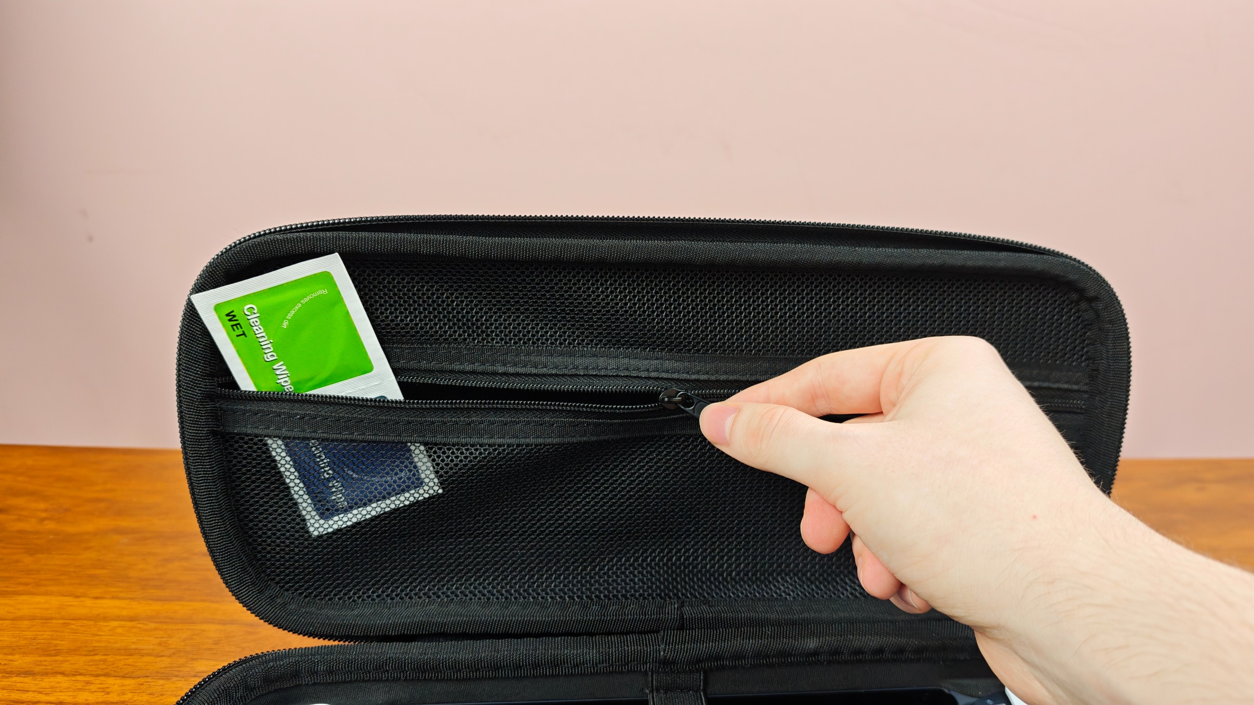 Man zipping up the inner compartment of the Venom PlayStation Portal Carry Case
