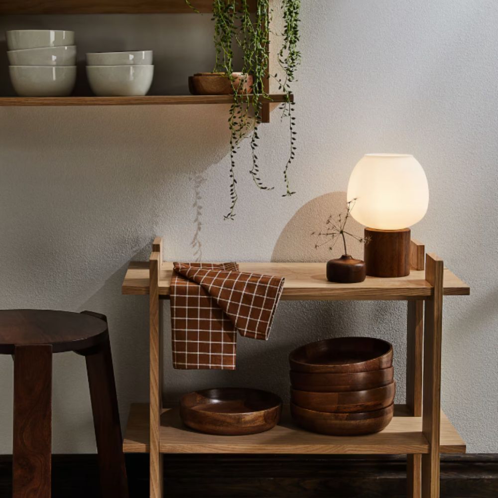wooden lamp on wooden shelf with wooden bowls and stool