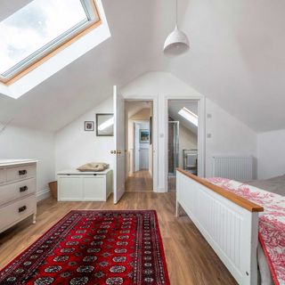 loft conversion bedroom with en suite bathroom and roof windows and wooden flooring