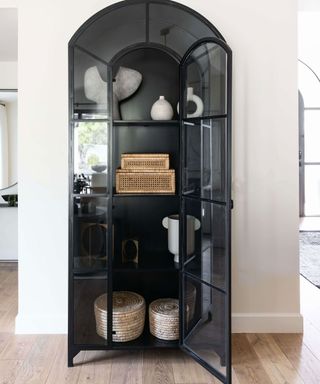 Black hutch filled with modern ornamental home decor in organic forms