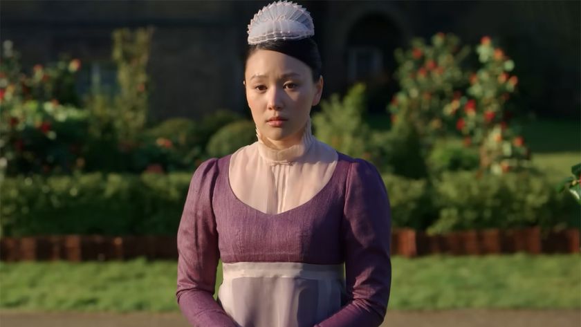 Sophie, played be Yerin Ha, in a full purple maid costume standing outside in Bridgerton Season 4. 