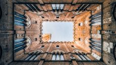 Skyward shot through medieval courtyard building