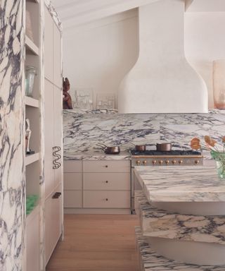 modern kitchen with grey and pink veined marble and curved extractor fan