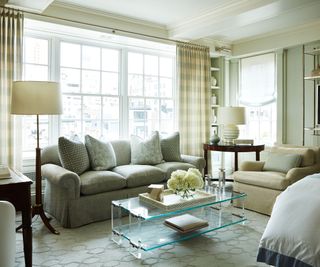 Neutral living room space with glass top coffee table and cream hydrangea on display